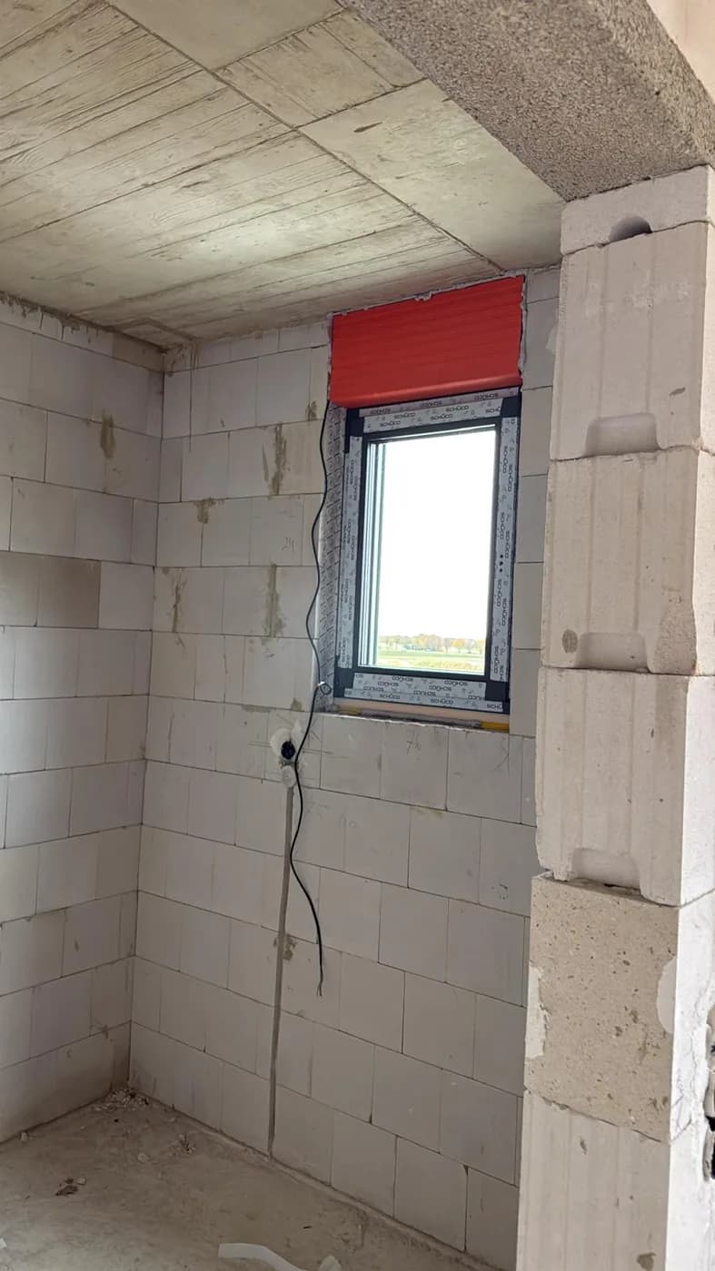 Schmales anthrazitgraues Fenster im Rohbau, Ansicht von innen